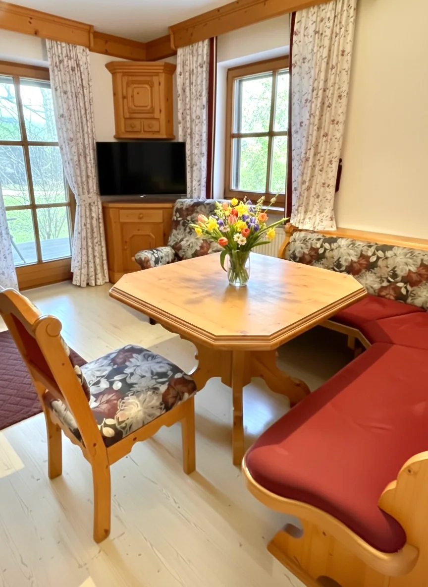 Wohn-und Essbereich mit Eckbank Bayerische Eckbank und Esstisch im hellen Erker der Ferienwohnung Bergveilchen mit Blick auf die Alpen