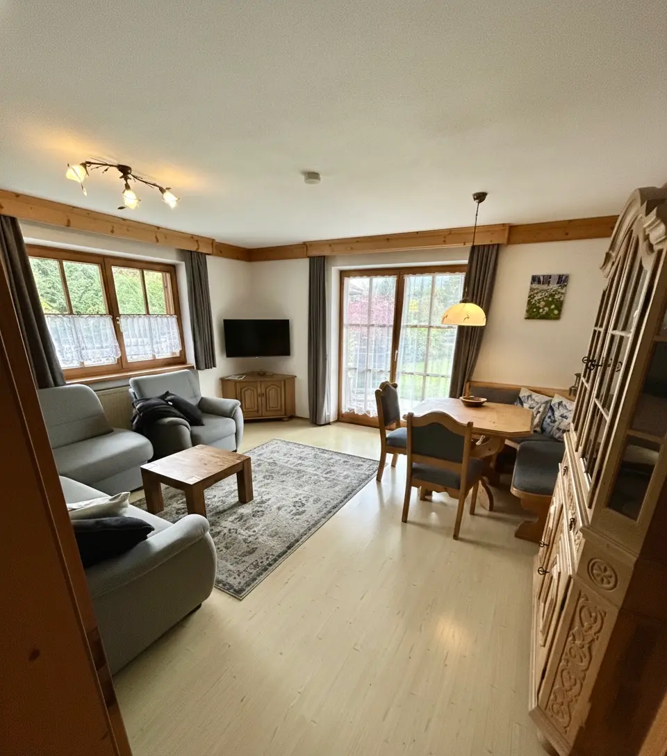 Großzügiger Wohn-und Essbereich Wohnzimmer der Ferienwohnung Enzian in Reit im Winkl mit gemütlicher Couch und Kupfer-Dekoration.