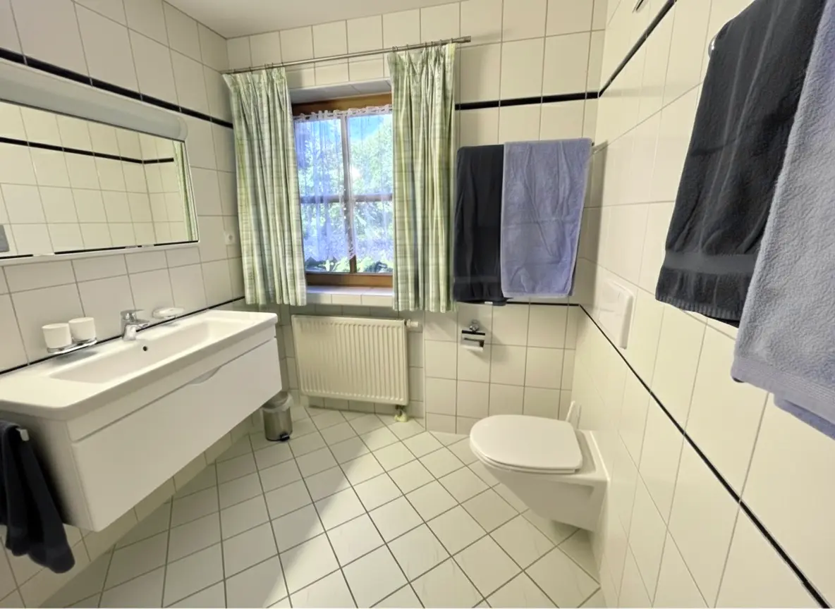 Badezimmer Helles Badezimmer in der Ferienwohnung Enzian mit Föhn und Kosmetikspiegel und weichen Handtüchern in Reit im Winkl.
