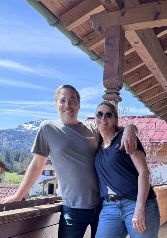 Gastgeber Daniel und Barbara des Haus am Wiesbach der Ferienwohnungen in Reit im Winkl  mit Blick auf dei Bergpracht.