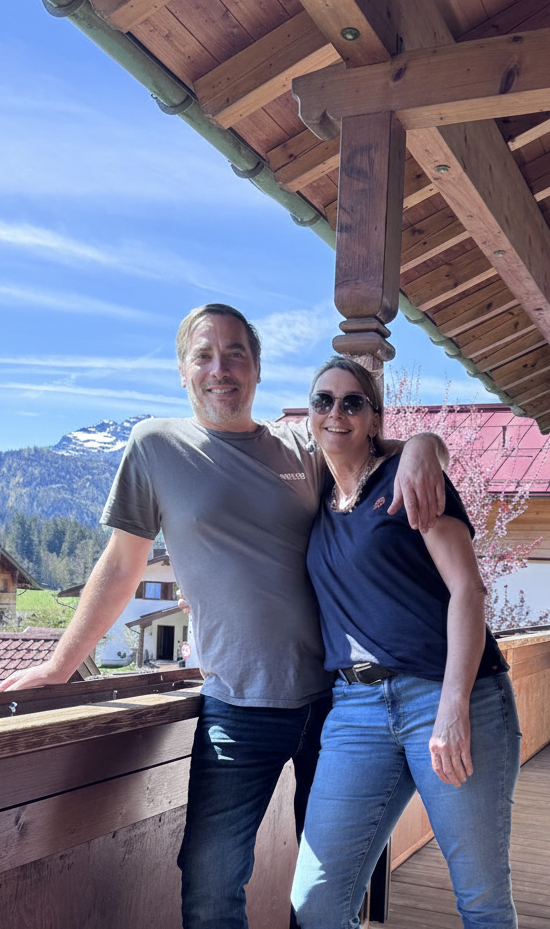 Gastgeber Daniel und Barbara des Haus am Wiesbach der Ferienwohnungen in Reit im Winkl  mit Blick auf dei Bergpracht.