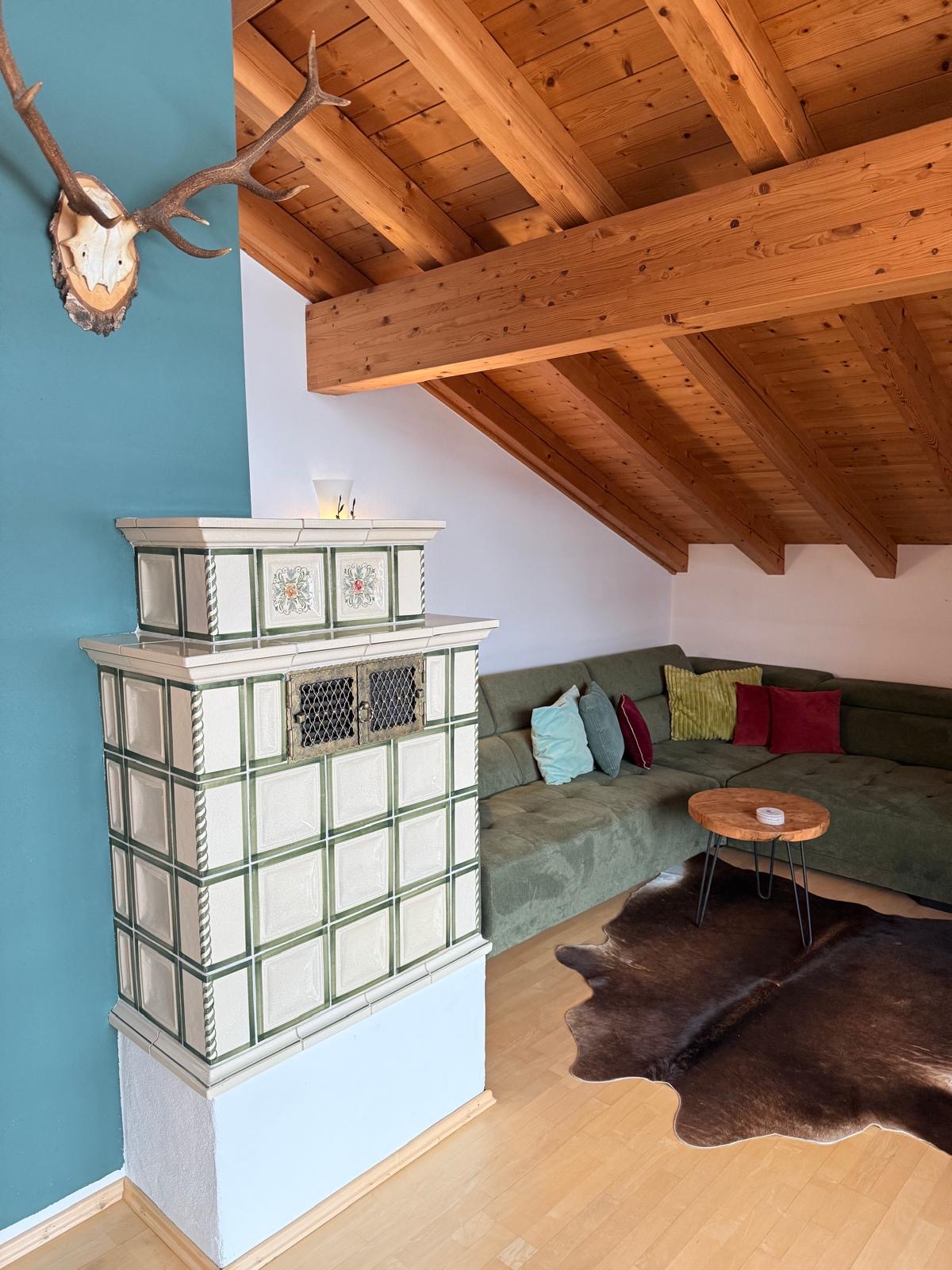 Wohnzimmer mit Kachelofen Großzügiges Dachgeschoss-Wohnzimmer mit elektrischem Kachelofen und Plattenspieler im Haus am Wiesbach.