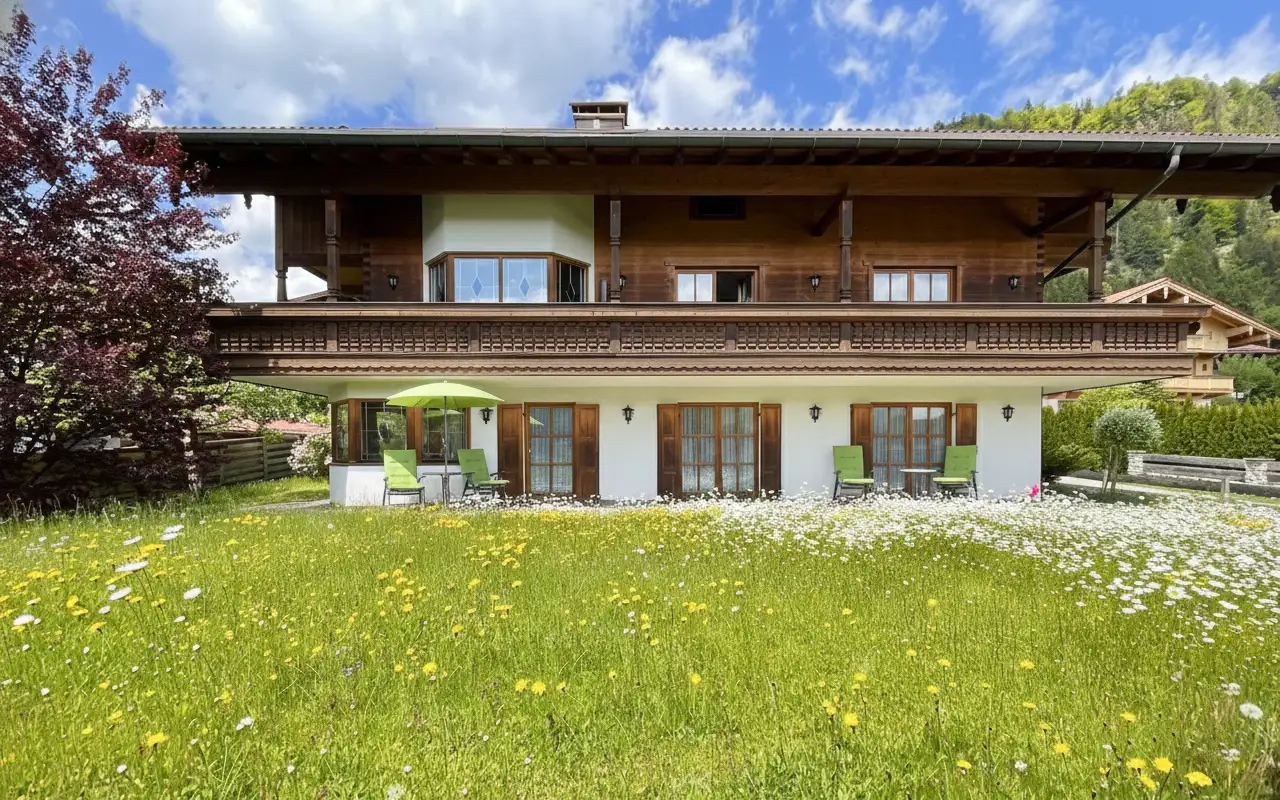 Terasse mit Gartenzugang und Bergblick Terrasse der Ferienwohnung Enzian in Bayern mit Sonnenliegen, Schirm und Blick auf das Alpenpanorama.