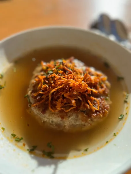 Hausgemachte Kaspressknödel in einer kräftigen Rinderbrühe auf einer Almhütte.