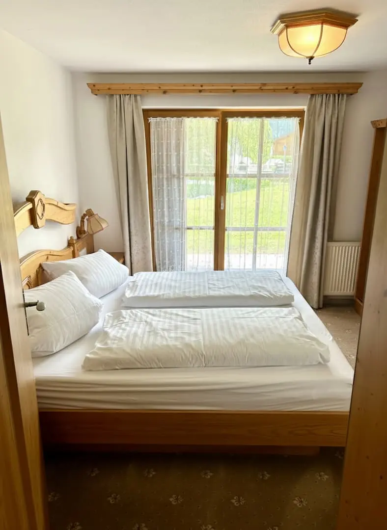 Schlafzimmer mit Bergblick Gemütliches Schlafzimmer im bayerischen Stil mit großem Doppelbett und hochwertiger Bettwäsche im Haus am Wiesbach