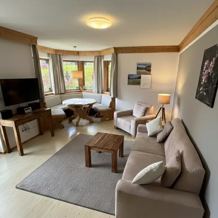 helles, barrierefreies Wohnzimmer der Ferienwohnung Bergveilchen mit Alpenblick gemütlich eingerichtet mit Gartenzugang 